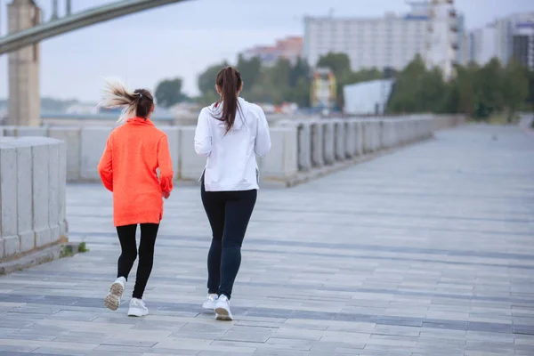 两名妇女在一条城市街道上参加了一个培训班 在人行道上跑步 背景色 — 图库照片