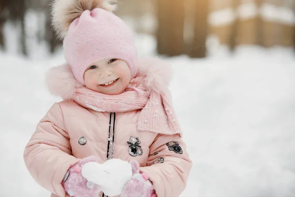 Dziewczynka Różowym Kombinezonie Czapce Pomponem Bawi Się Białą Śnieżką Słoneczny — Zdjęcie stockowe