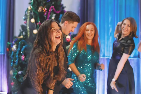 一群快乐的朋友在圣诞树旁跳舞 女人笑 — 图库照片