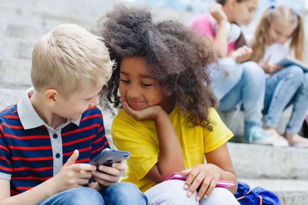 Deux Écoliers Une Fille Afro Américaine Garçon Blond Regardent Smartphone — Photo