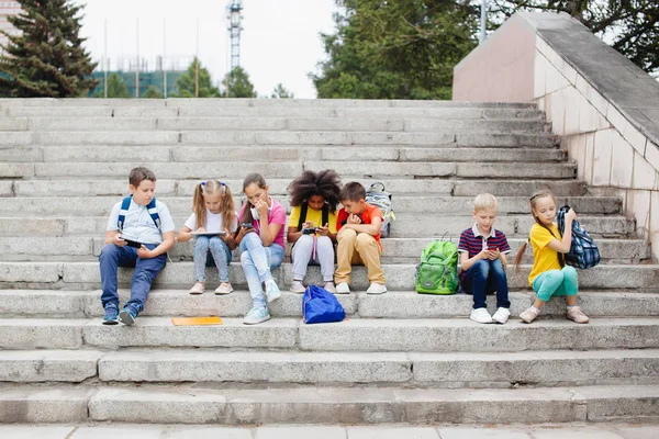 Különböző Nemzetiségű Iskolások Csoportja Színes Ruhában Akik Kőlépcsőn Ülnek Tinédzserek — Stock Fotó