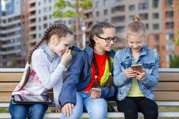 Tres Adolescentes Con Teléfono Inteligente Sientan Banco Parque Verano Ciudad —  Fotos de Stock