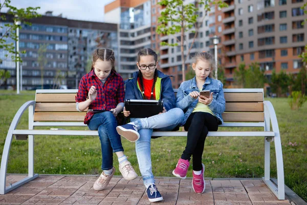 Trois Adolescentes Avec Smartphone Tablette Assises Sur Banc Dans Parc — Photo