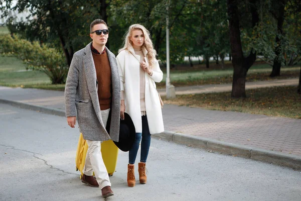 Due Eleganti Uomo Una Donna Con Una Valigia Gialla Camminano — Foto Stock