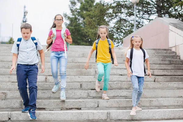 Dzieci Nastolatki Kolorowych Ubraniach Plecakami Wchodzą Schodach Szkoły — Zdjęcie stockowe
