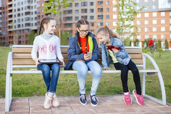Три Девочки Подростка Смартфоном Сидят Скамейке Летнем Городском Парке — стоковое фото