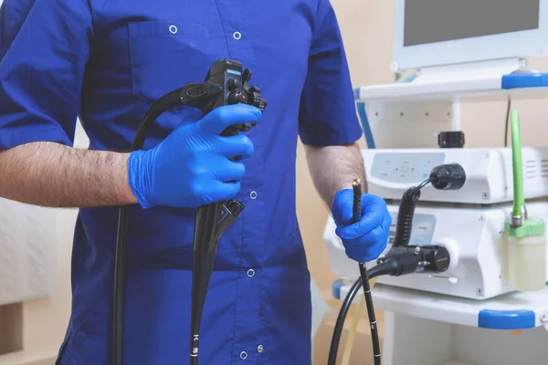 Gastroskopi, endoskopi. Doktor 'un elleri, karın boşluğu araştırması için ameliyat aparatına hazırdır: fibrogastroduodenoskopi, mide incelemesi.