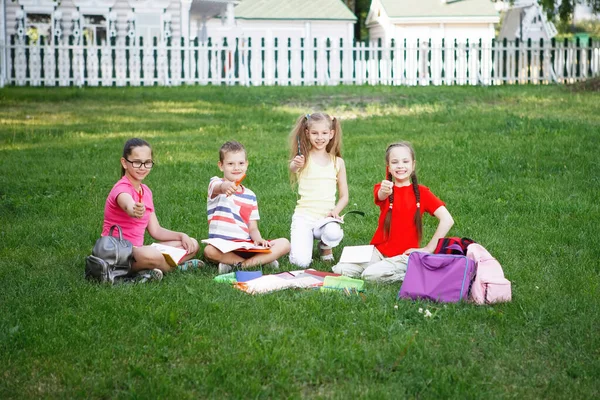 Dzieci Siedzą Trawie Trawniku Parku Miejskim Pokazują Ołówki Dłoniach — Zdjęcie stockowe