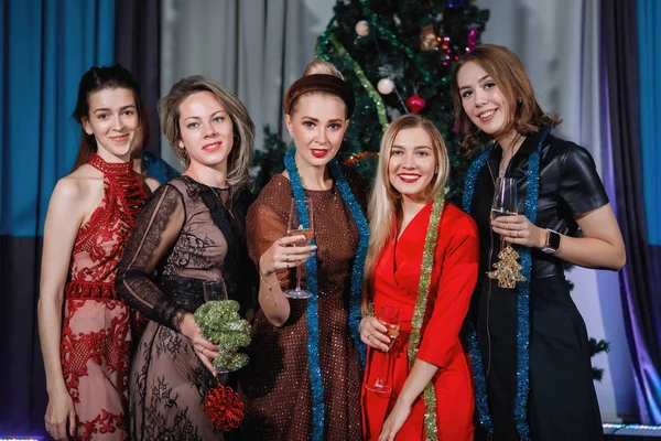 女朋友们在圣诞树旁庆祝圣诞节和新年 女人用香槟酒碰杯 笑着庆祝 — 图库照片