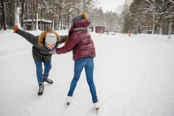 Mädchen Bringt Einem Mann Bei Winter Auf Einer Eisbahn Schlittschuh — Stockfoto