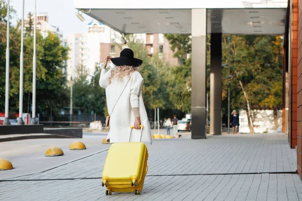 Γυναίκα Μπότες Αστραγάλου Καπέλο Κίτρινη Βαλίτσα Μπεζ Παλτό Που Περπατάει — Φωτογραφία Αρχείου