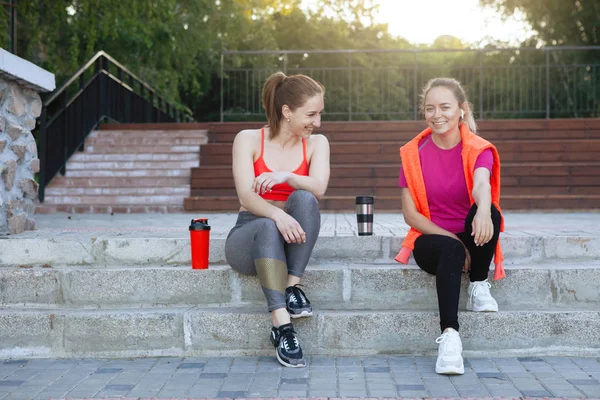 两个女运动员正坐在城市的台阶上休息 — 图库照片