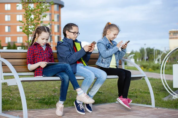 Trois Adolescentes Avec Smartphone Tablette Assises Sur Banc Dans Parc — Photo