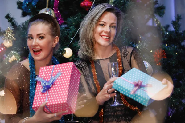 Twee Vriendinnen Geven Elkaar Cadeaudozen Bij Een Kerstboom — Stockfoto