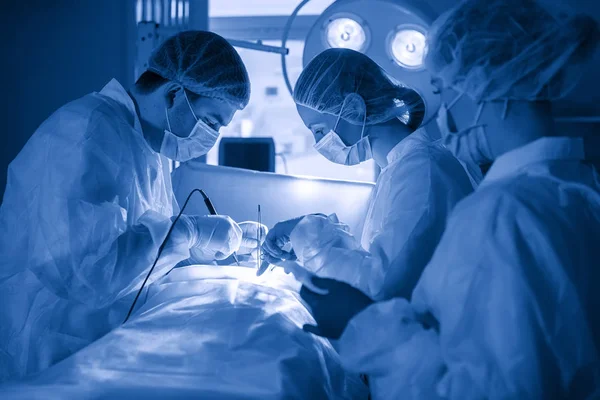 Trzech Chirurgów Podczas Operacji Brzucha Niebieskie Mundury Lateksowe Rękawiczki Instrumenty — Zdjęcie stockowe