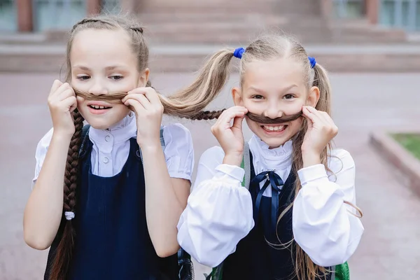 Zwei Schulmädchen Uniform Amüsieren Sich Machen Schnurrbärte Aus Zöpfen — Stockfoto