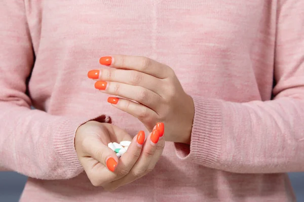 Coronavirus epidemic. Woman pours pills from hand to hand.