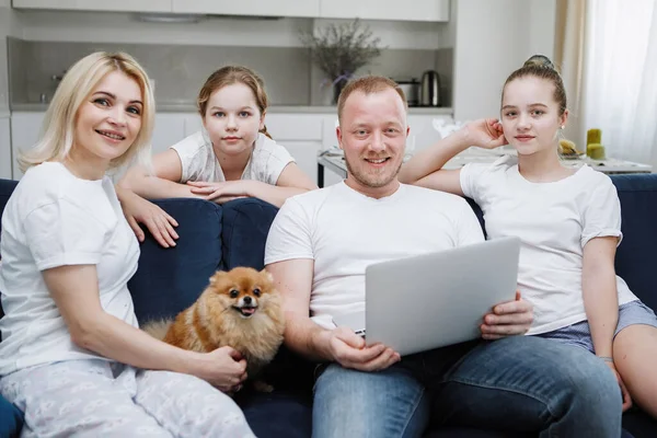 Uma Jovem Família Quatro Pessoas Está Sentada Sofá Com Cachorro — Fotografia de Stock