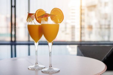 İki bardak portakal suyu ve dilimler masanın üzerinde duruyor.