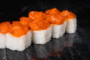 Karides sosundan Japon suşisi, siyah mermer arka planda pirinç..