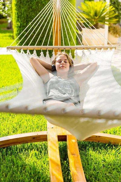Girl relaxing and listening to music in hammock — Stock Photo, Image
