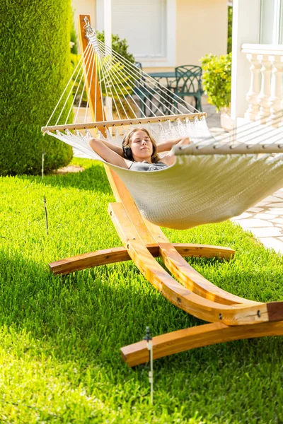 Chica relajante y escuchando música en hamaca —  Fotos de Stock