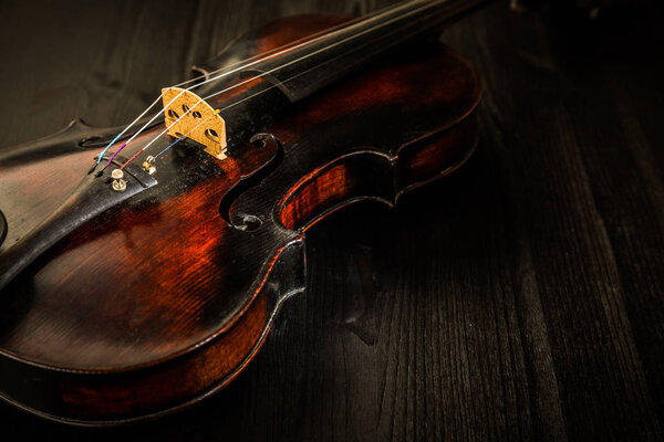 Old violin in vintage style on wood background