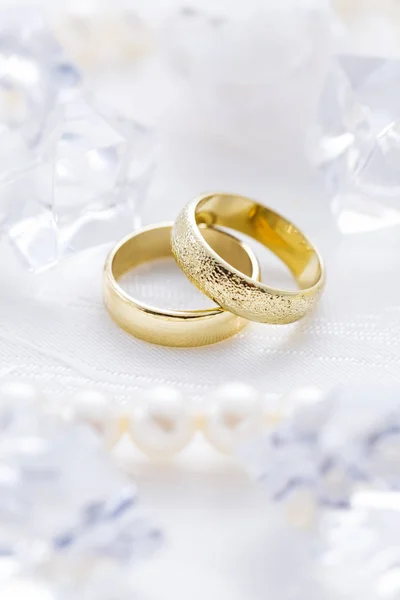 Dva zlaté prsteny s perleťovým náhrdelníkem a na bílém pozadí — Stock fotografie