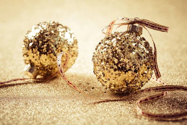 Boules de Noël dorées sur fond pailleté avec espace de copie — Photo