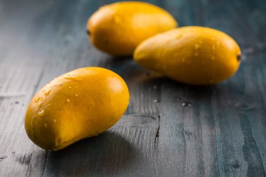 Ahşap arka planda taze ballı mango meyveleri. Meksika 'dan Ataulfo (mango).