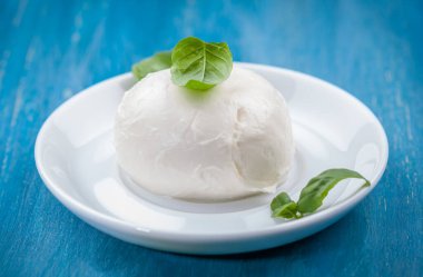 Fesleğen yapraklı lezzetli bufalo mozzarella porsiyonu. İtalyan lezzeti.