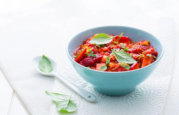 Fresh strawberry mango salsa gardnished with Thai basil on white background