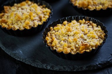 Küçük ve lezzetli elmalı turtalar ya da siyah arka planda elmalı turtalar. Elmalı tart.