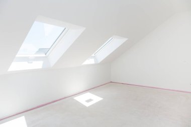Loft refurbishment - empty room with skylight ready for renovation and new floor clipart