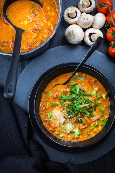 Pizza soup - making use of leftovers for cooking. Fresh homemade soup with tomato, champignon, beef, corn and mozzarella cheese — Stock Image Pizza Soup Making Use Leftovers Cooking Fresh Homemade Soup Tomato Royalty Free Stock Photos
