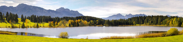 Panorama scene in Bavaria with mountains mirroring in lake