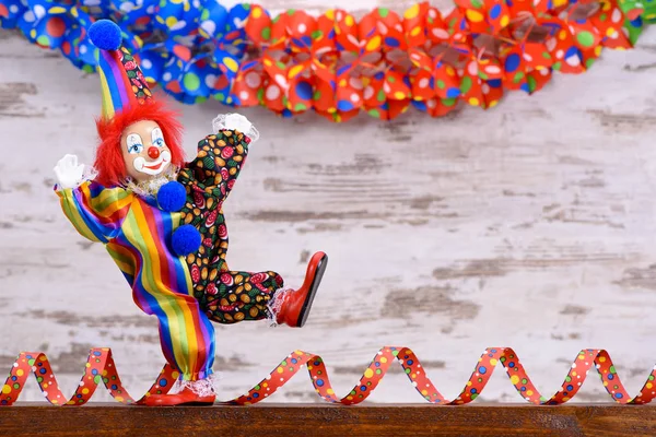 Palhaço engraçado com traje colorido e streamer de papel — Fotografia de Stock