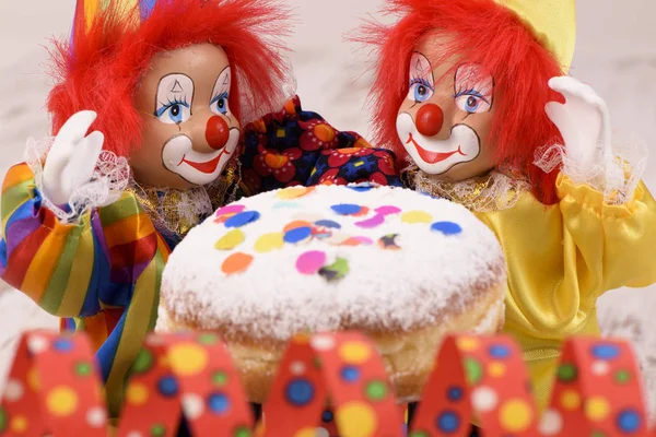 Palhaço com cabelos vermelhos e donut doce no carnaval — Fotografia de Stock