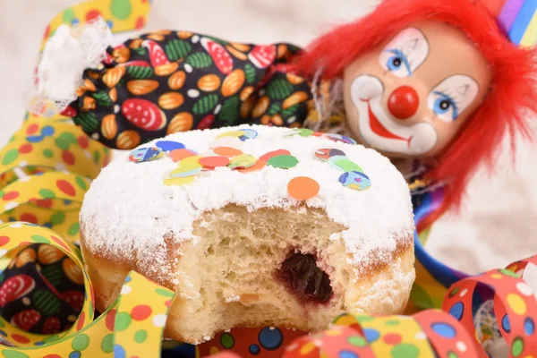 Palhaço com cabelos vermelhos e donut doce no carnaval — Fotografia de Stock