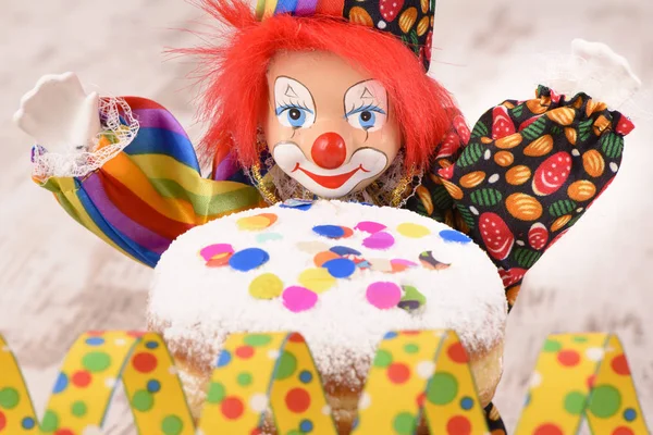 Palhaço com cabelos vermelhos e donut doce no carnaval — Fotografia de Stock