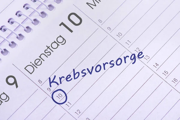 Calendar marked with an appointment for cancer screening, in german language: Krebsvorsorge — Stock Photo, Image