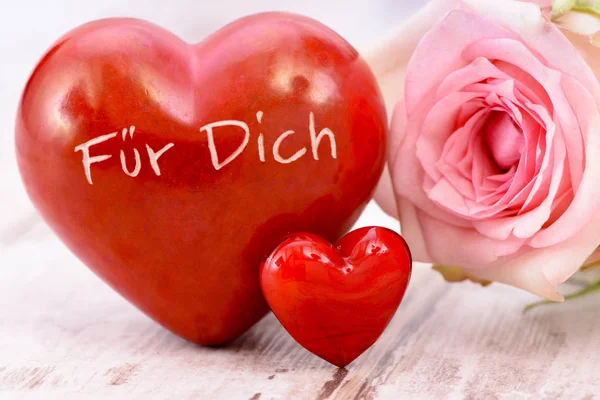 Цветок розы и сердце с надписью на немецком языке: для вас — стоковое фото