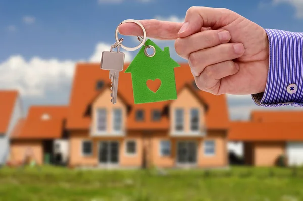 Nyckel i handen av fastighetsmäklare som erbjudande för nya bostadshus — Stockfoto
