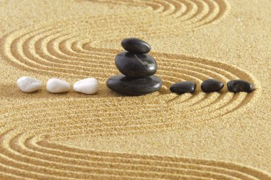 Japon Zen bahçesi ile dokulu kum içinde yığılmış taşlar