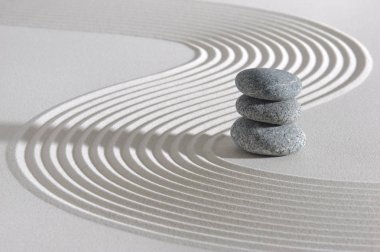 Japon Zen bahçesi ile dokulu kum içinde yığılmış taşlar