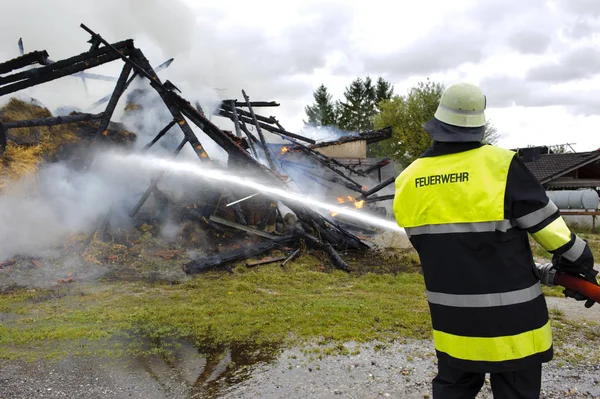 Fire brigade in action at burning farm house in Bavaria, Germany — Stock Photo, Image