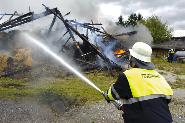 Fire brigade in action at burning farm house in Bavaria, Germany — Stock Photo, Image