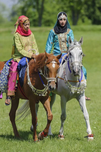Члены арабской шоу-группы "Королевская кавалерия Омана" ездят в красивых одеждах на лошадях — стоковое фото