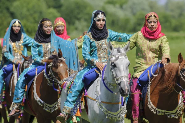 Members of the Arab show group "Royal Cavalry of Oman" ride in beautiful robes on horses — Stock Photo, Image