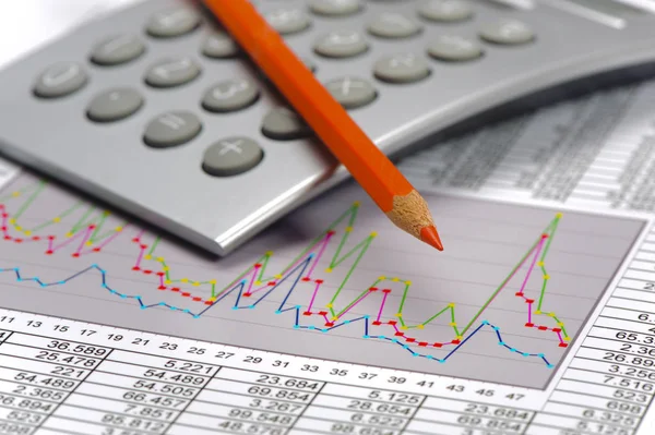 Calculator and pencil laying on financial business chart — Stock Photo, Image